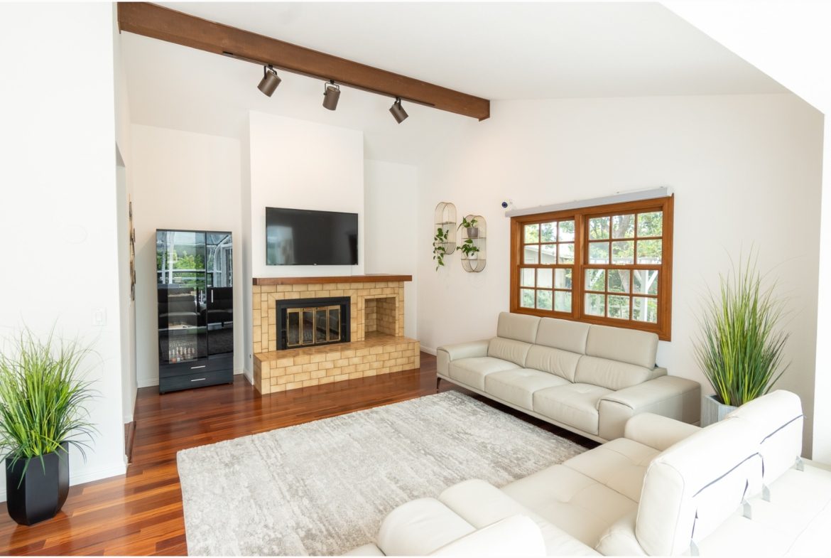 A living room with white couches and a fireplace.