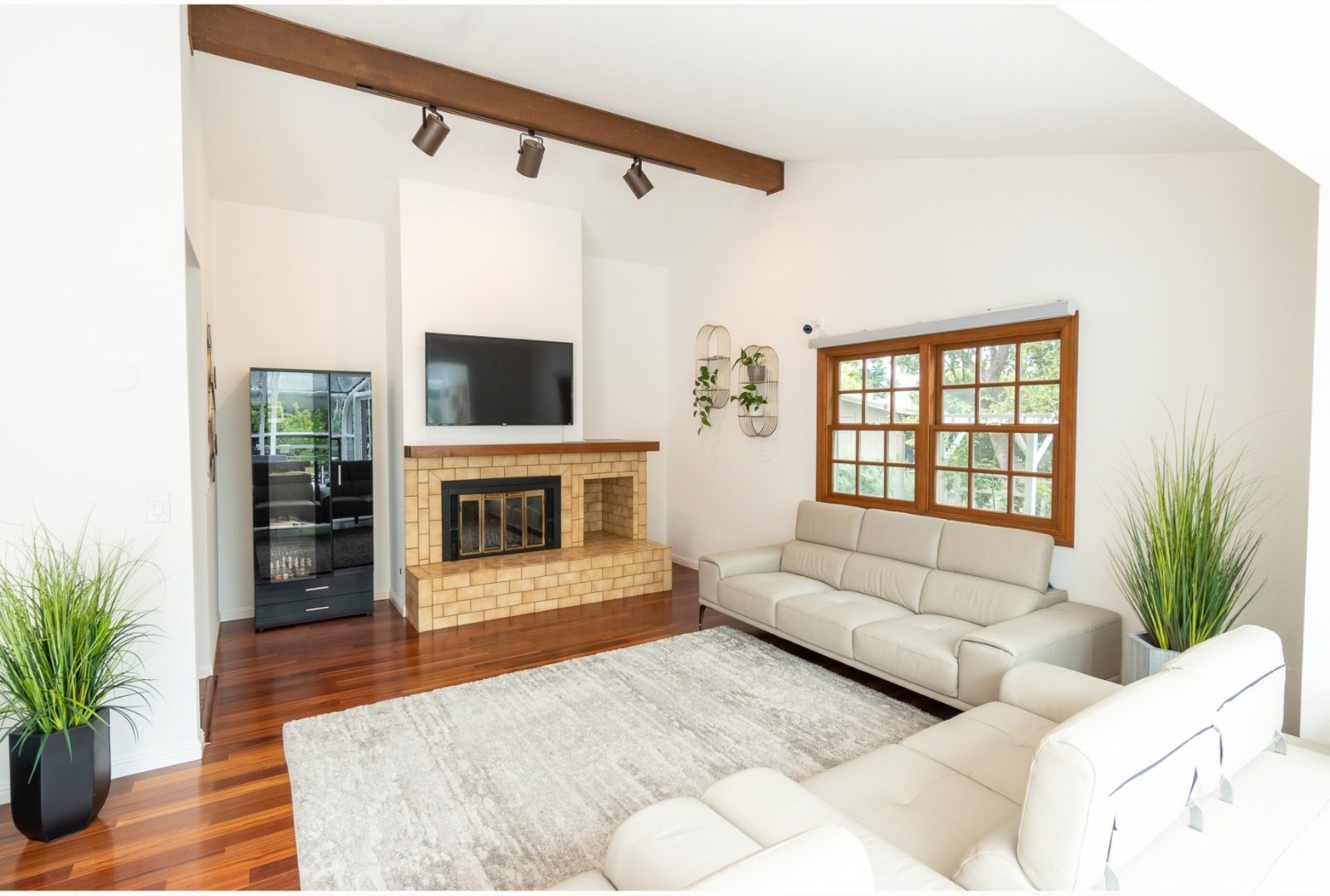 A living room with white couches and a fireplace.