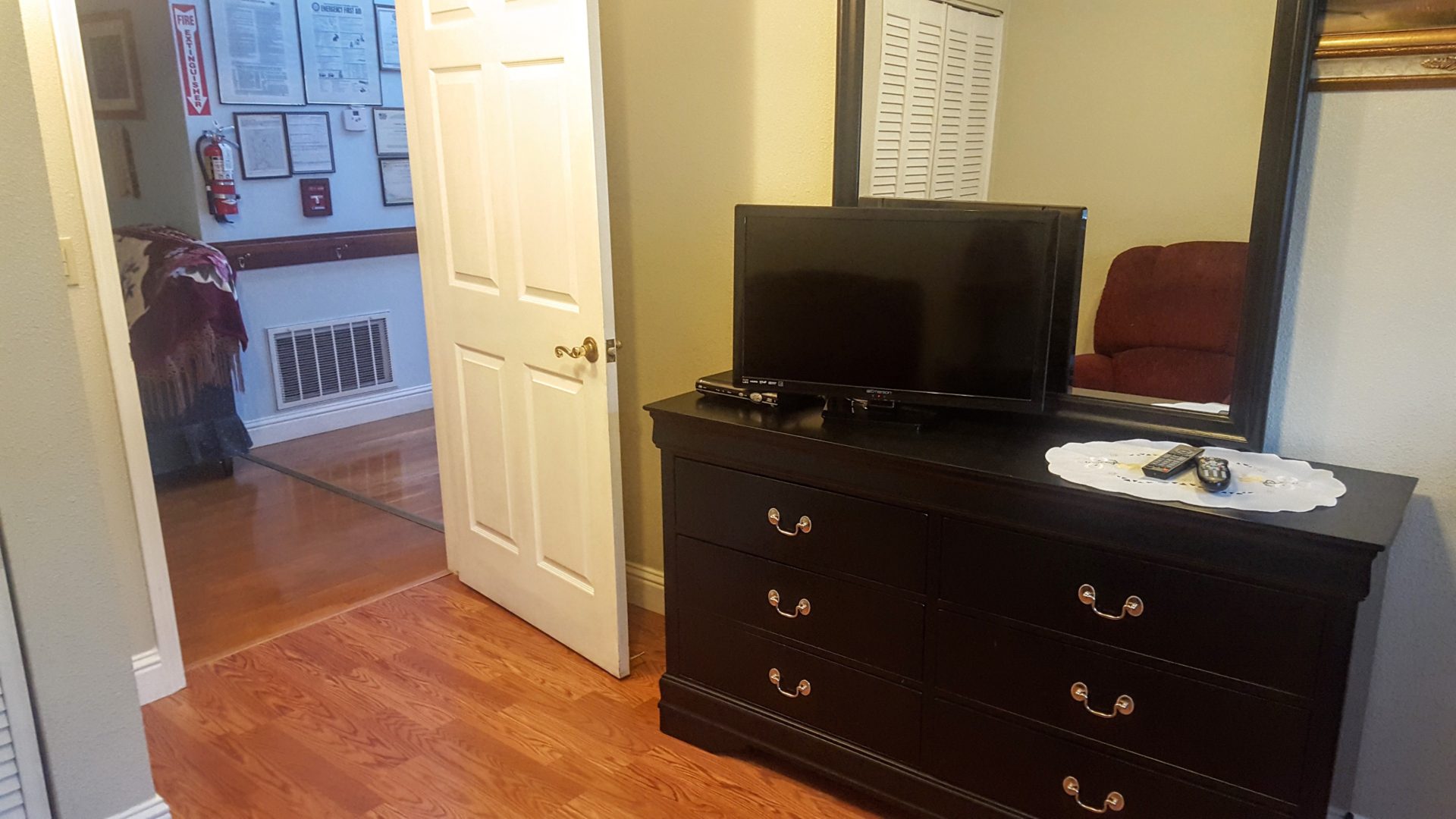 Bedroom dresser with TV and mirror.