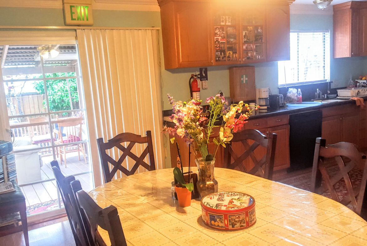 Kitchen with table, flowers, and outdoor view.