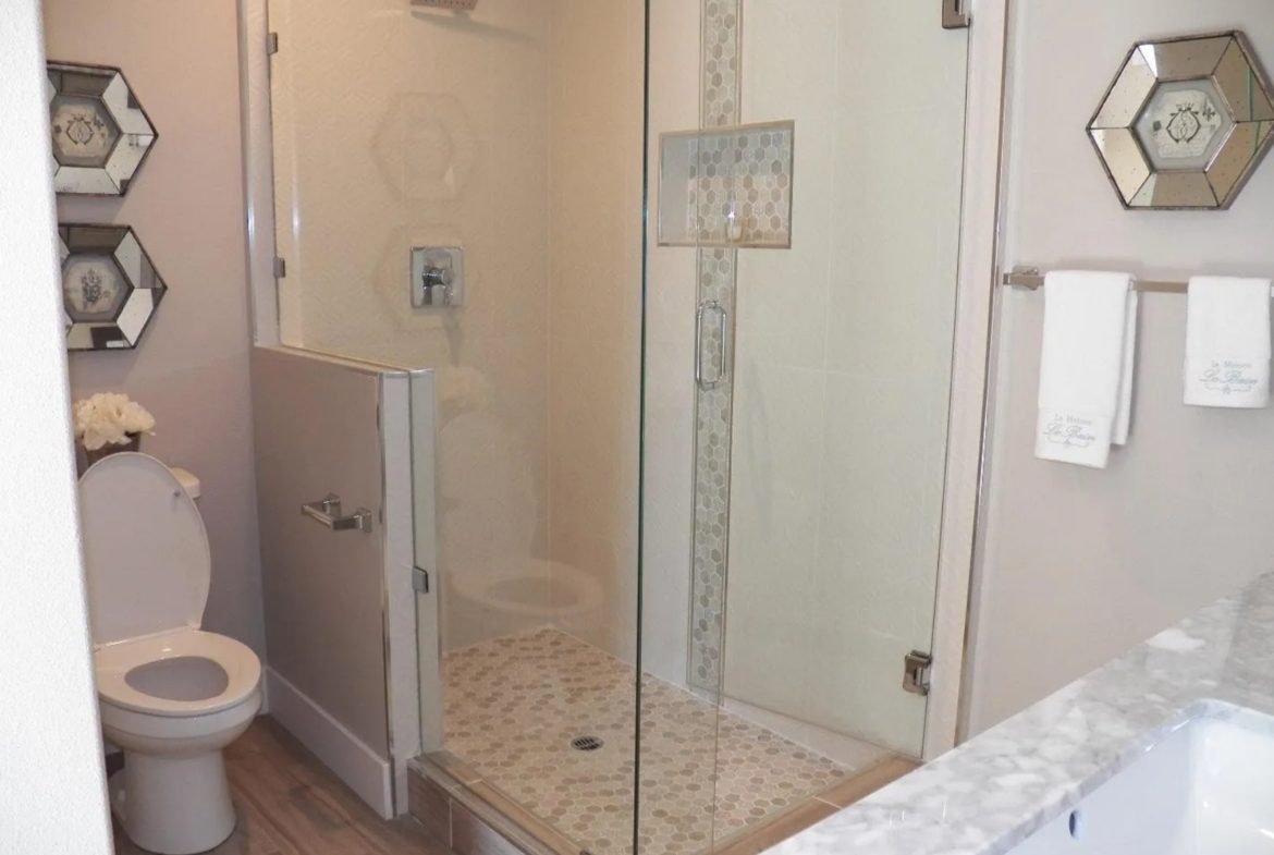 Modern bathroom with glass shower and toilet.