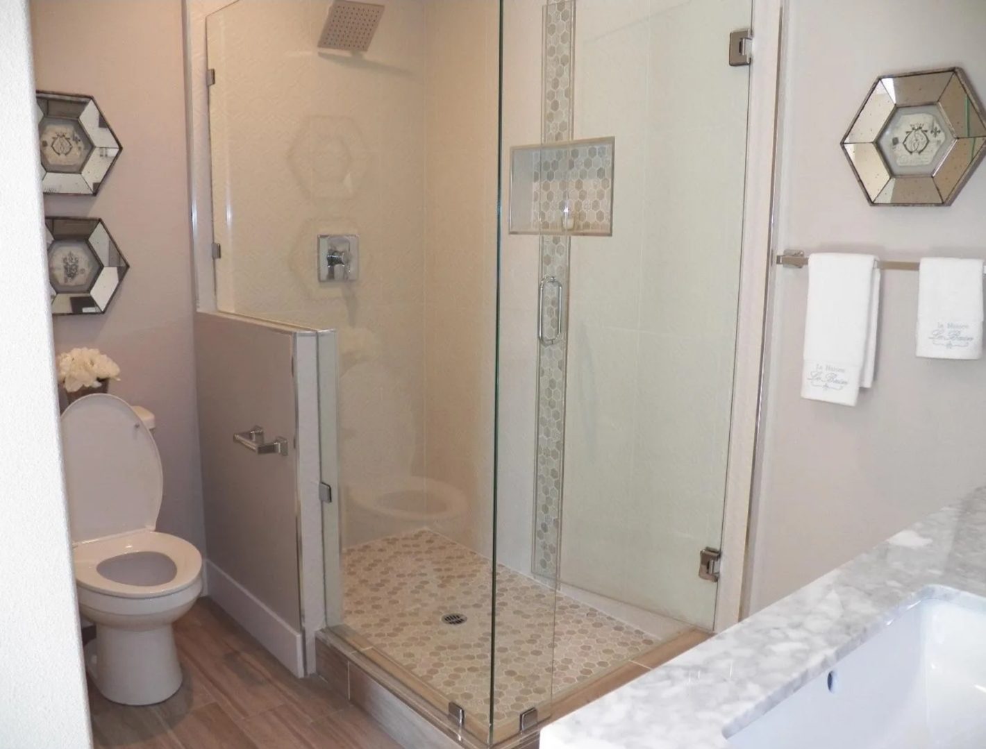 Modern bathroom with glass shower and toilet.