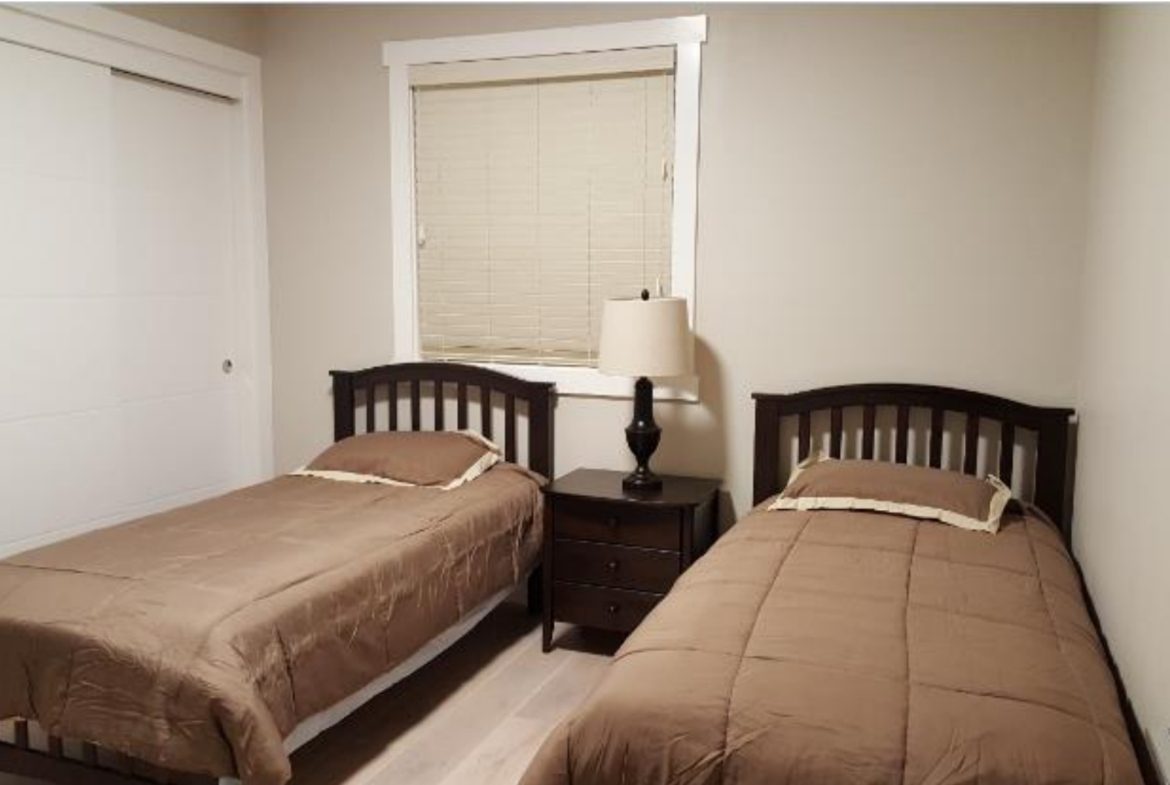 Bedroom with two beds and nightstand.