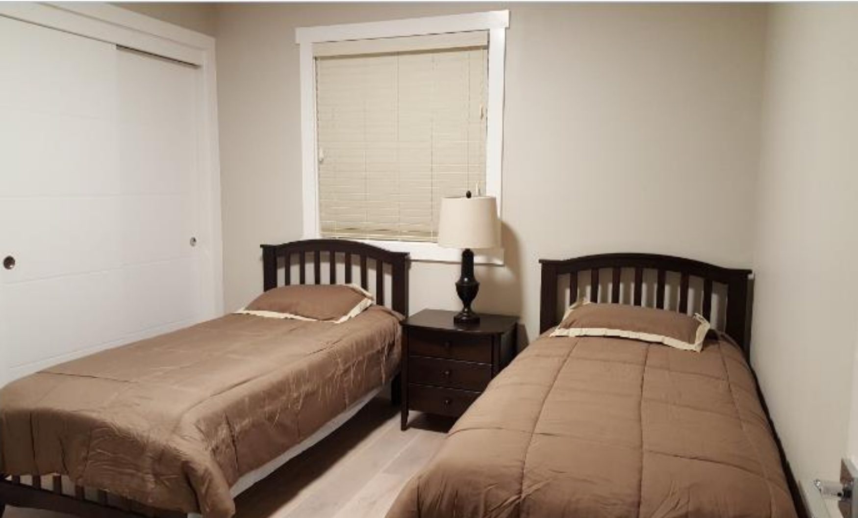 Bedroom with two beds and nightstand.