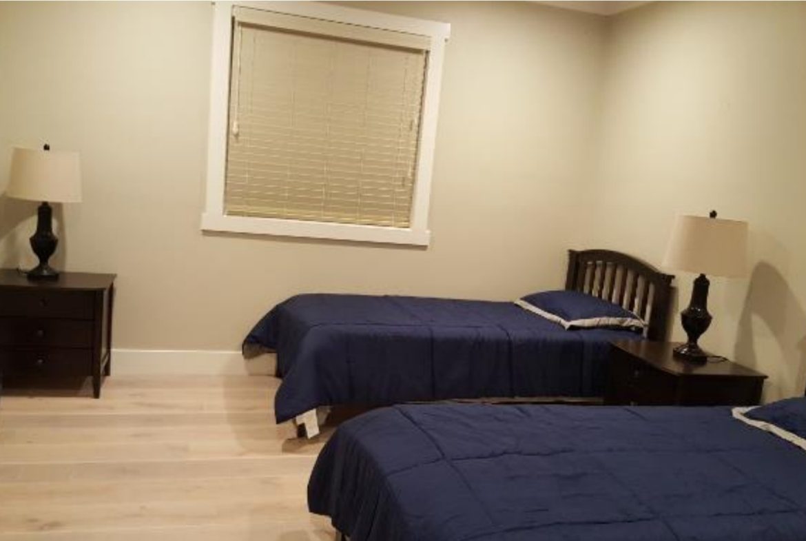 Bedroom with two beds and nightstands.