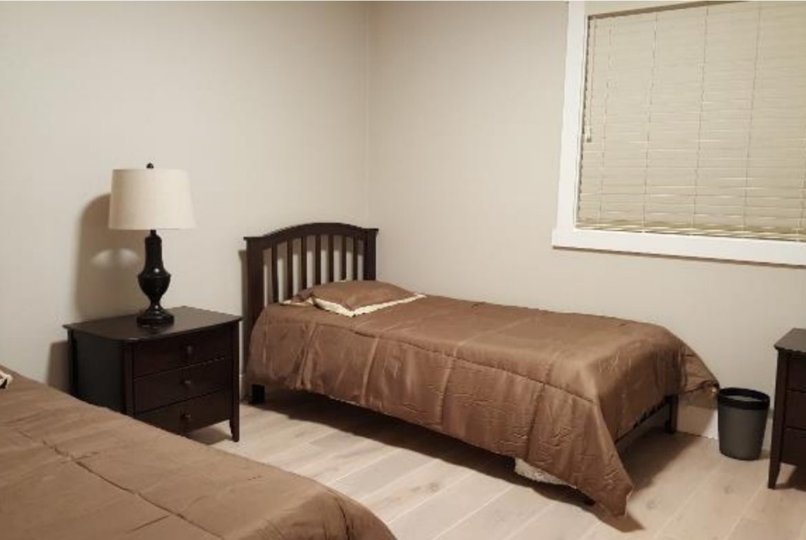 Two twin beds in a simple bedroom.