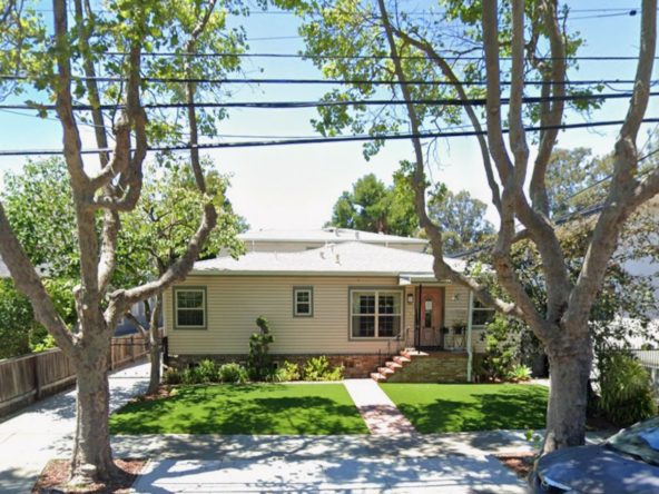 Single-story house with trees and lawn.