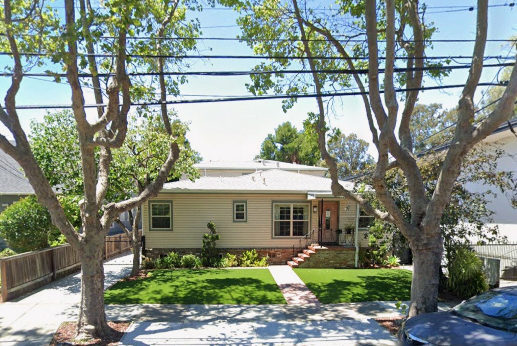 Single-story house with trees and lawn.