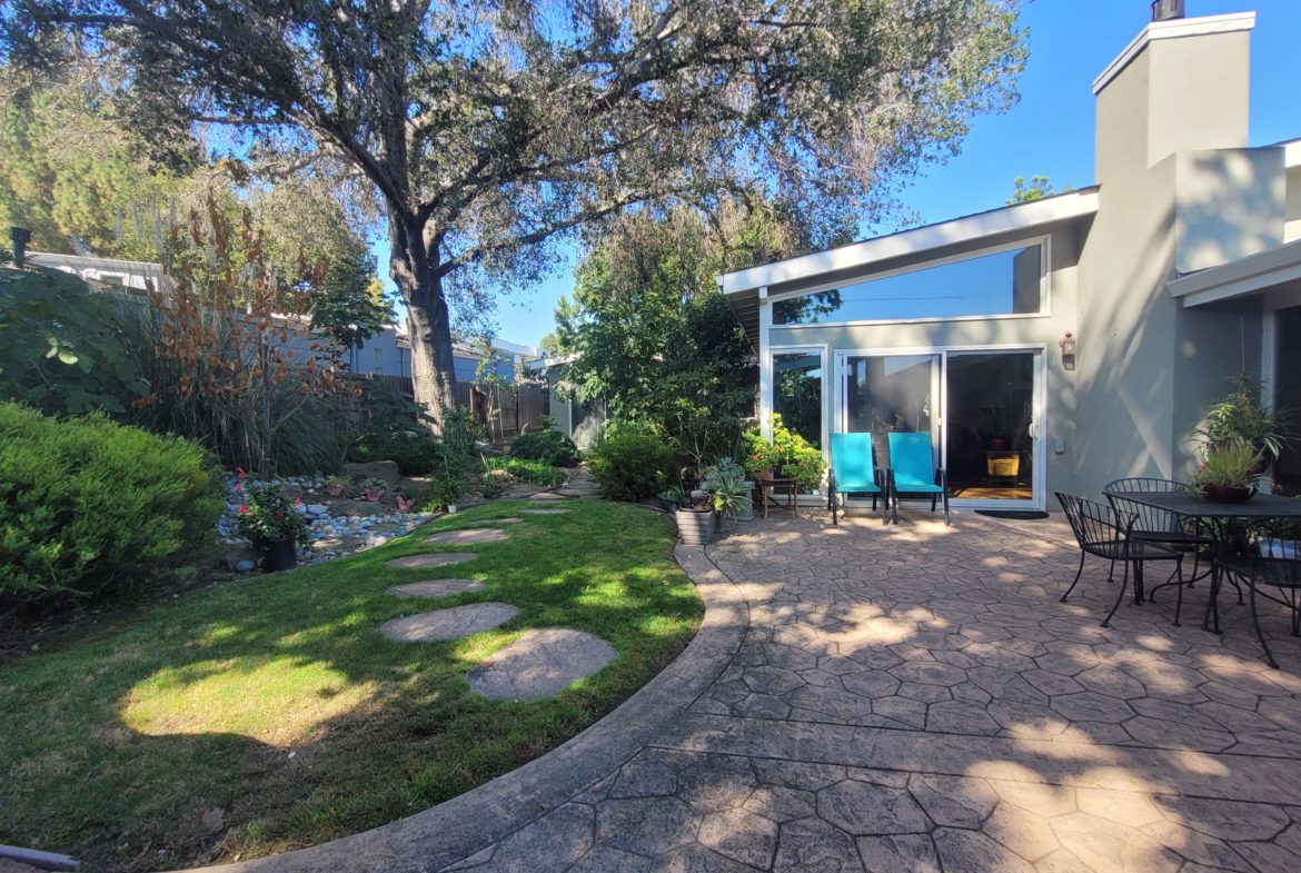 Modern patio with garden and seating area.