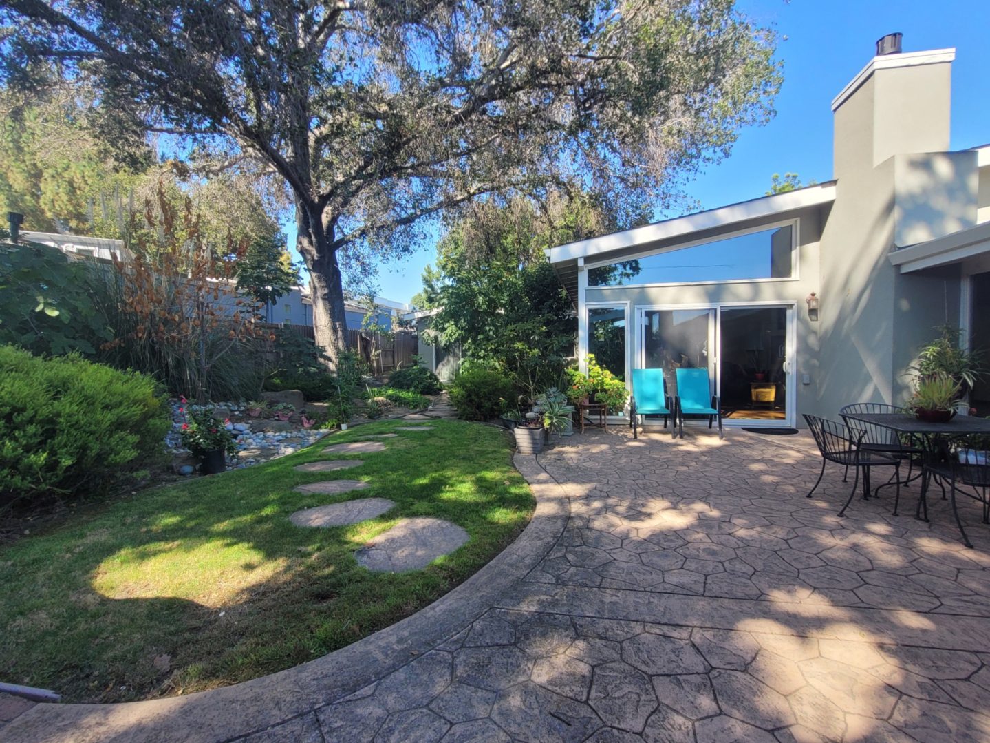 Modern patio with garden and seating area.