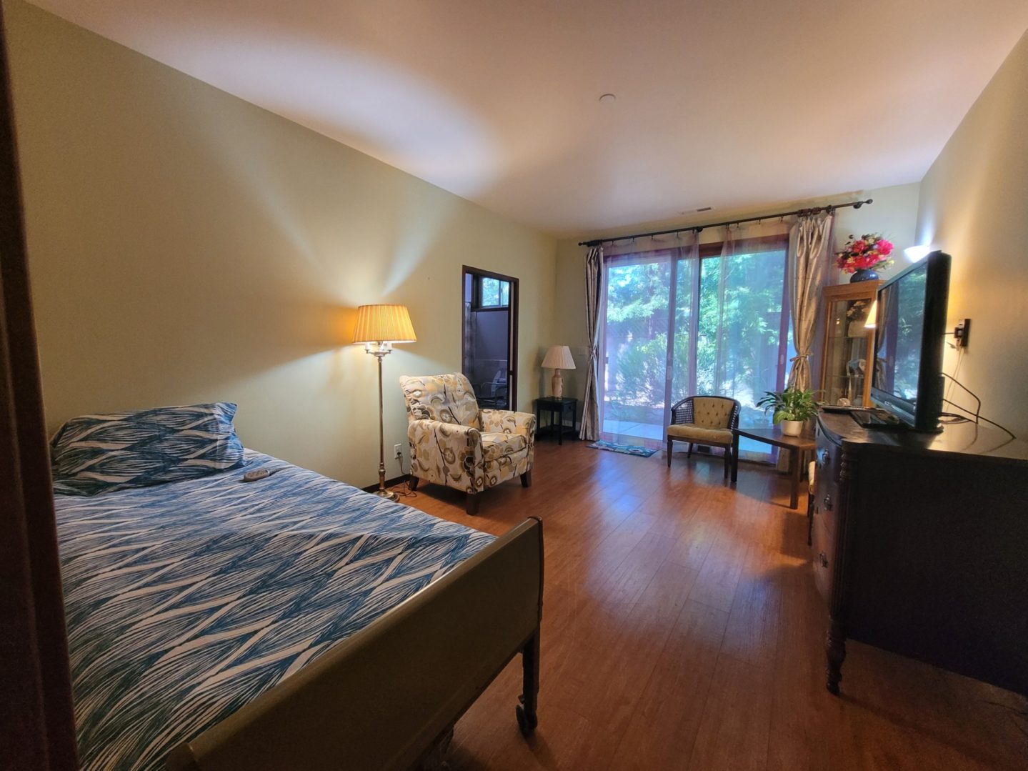 Bedroom with bed, chairs, and large window.