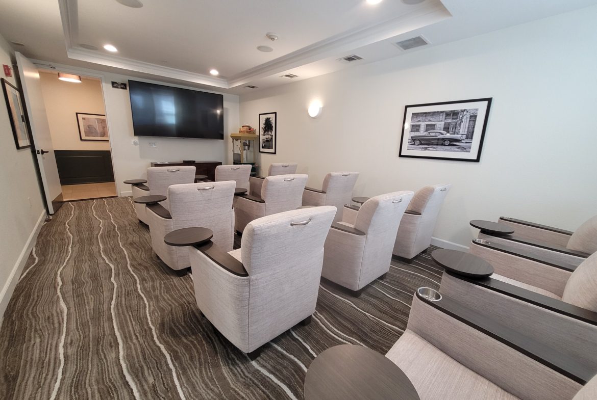 Small conference room with beige chairs and screen.