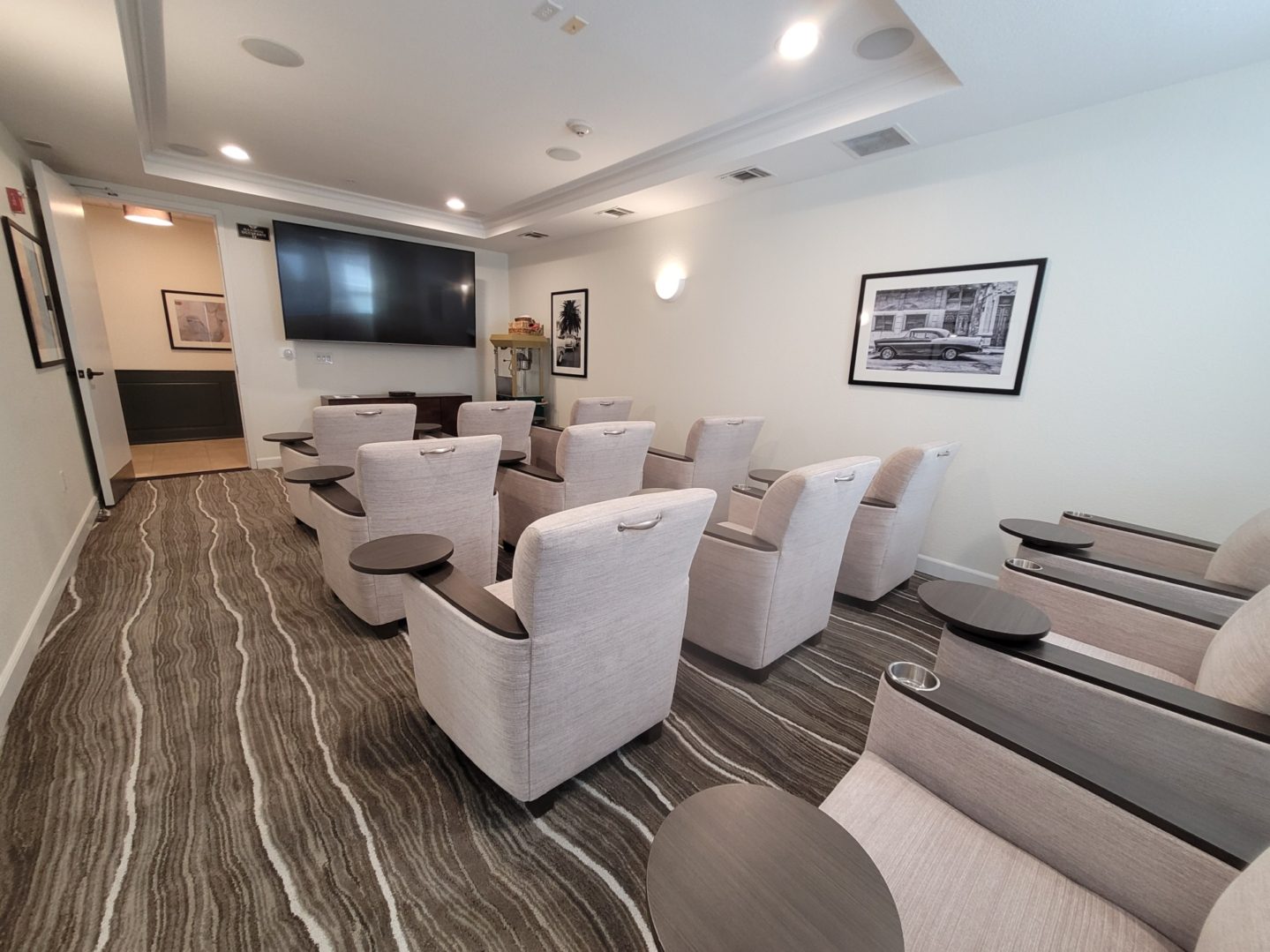 Small conference room with beige chairs and screen.