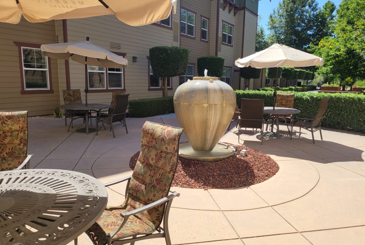 Outdoor patio with fountain and seating area.