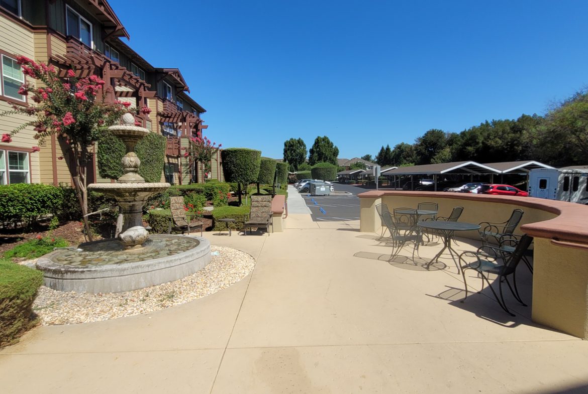 Outdoor patio with fountain and seating area.