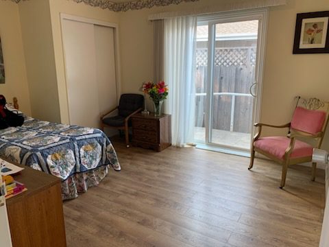 Cozy bedroom with wooden flooring and chair.