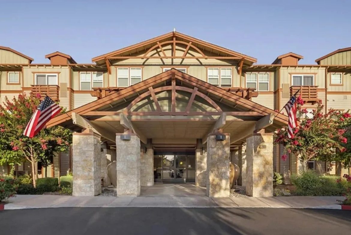 Building entrance with flags and glass canopy.