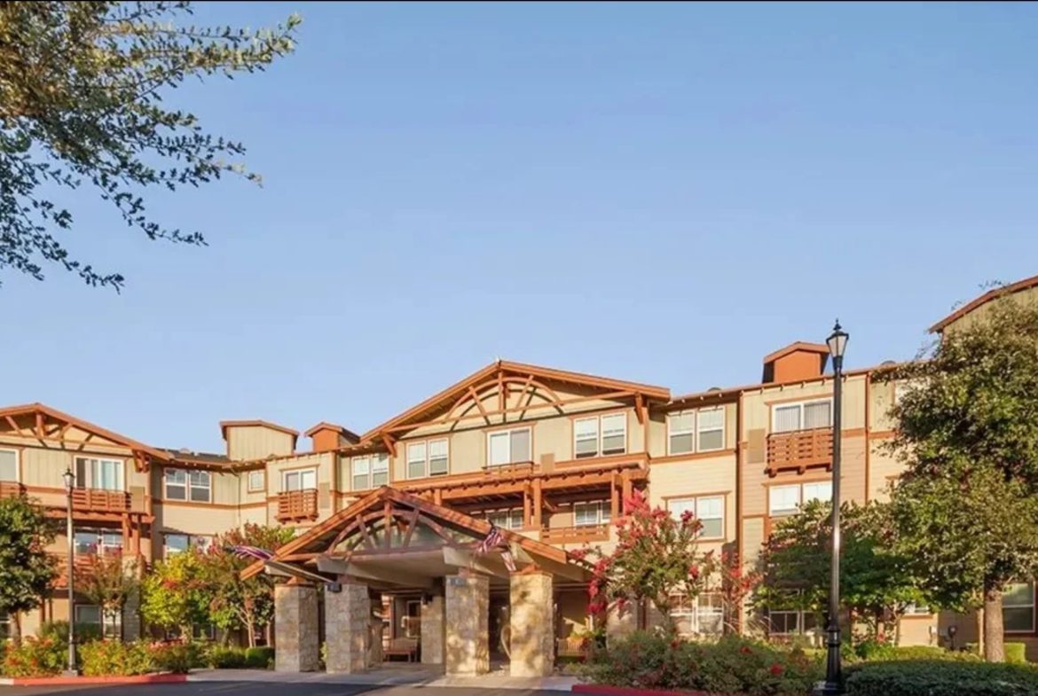Modern multi-story building with landscaped surroundings.