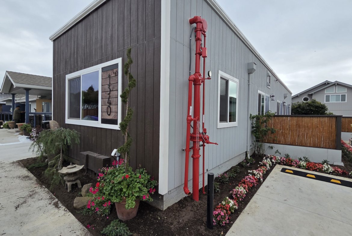 Modern house with garden and red pipes.