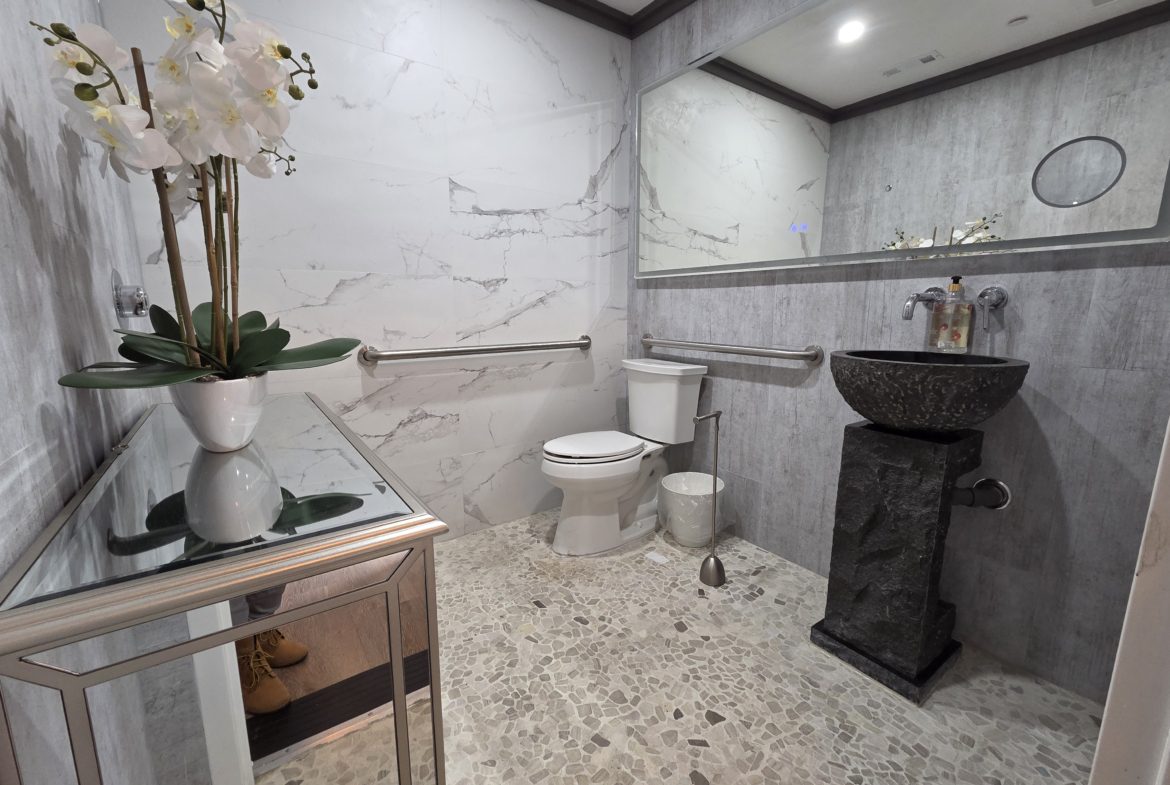 Modern bathroom with marble walls and sink.