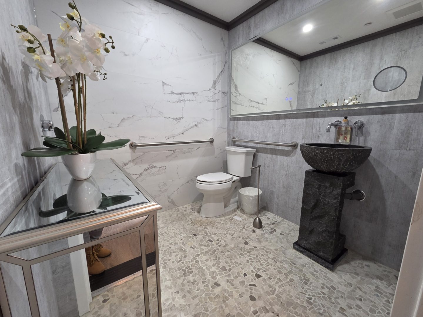 Modern bathroom with marble walls and sink.