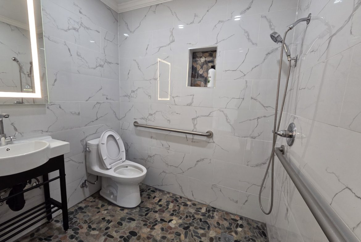 Accessible bathroom with shower and toilet.