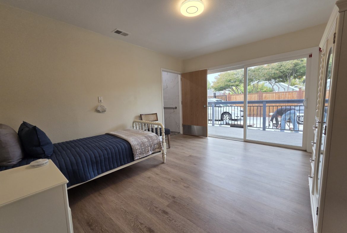 Spacious bedroom with sliding glass door.