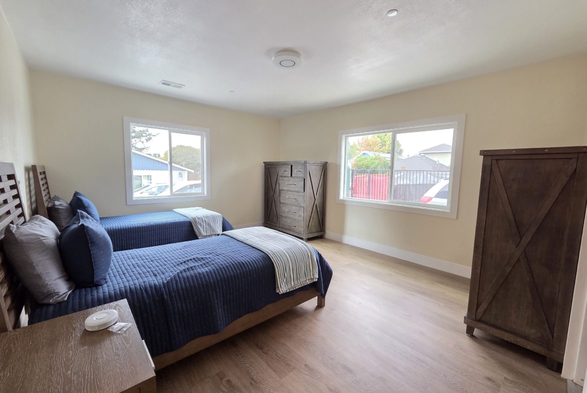 Bedroom with two beds and wooden furniture.