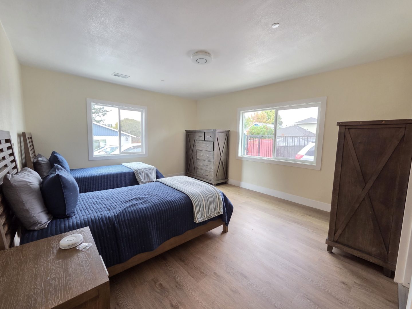 Bedroom with two beds and wooden furniture.
