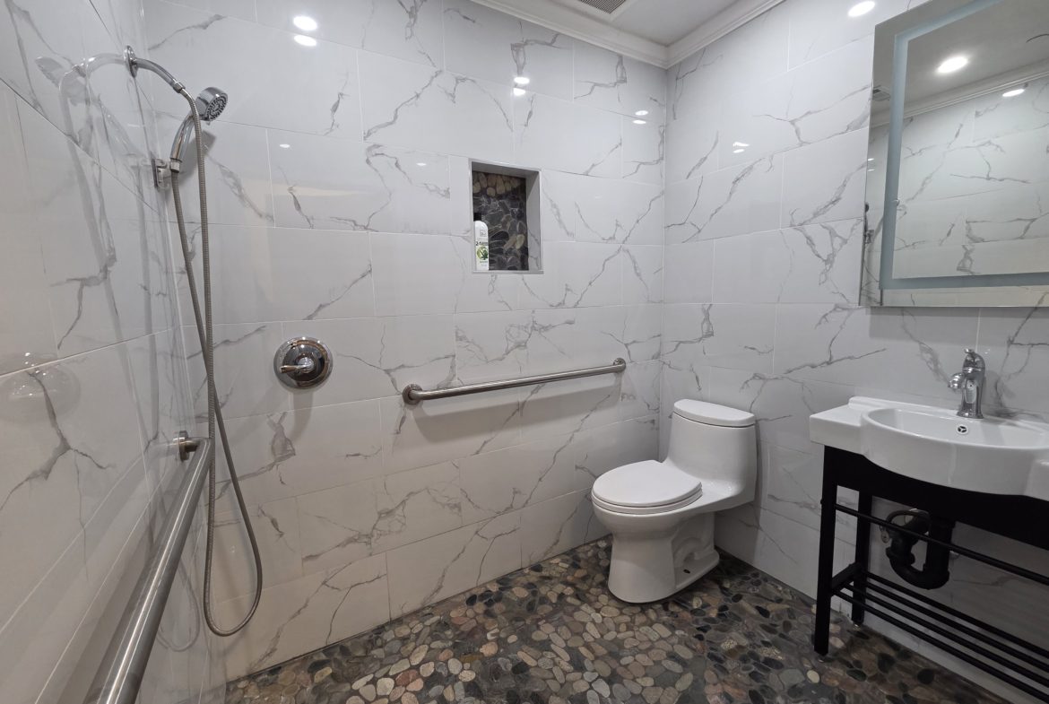Modern bathroom with shower and tiled floor.