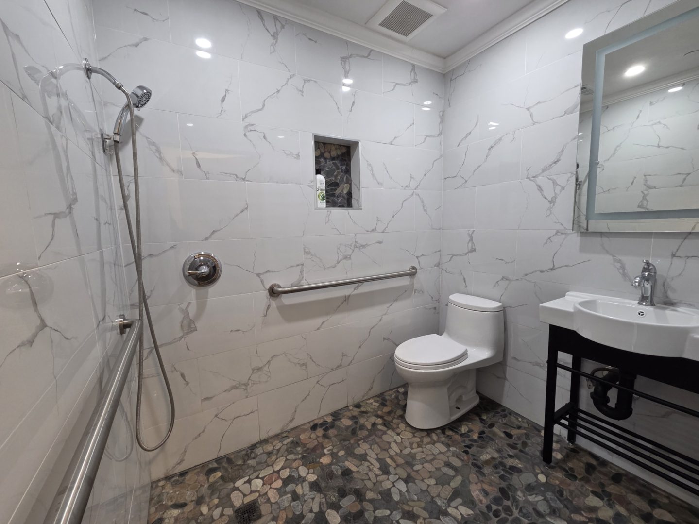 Modern bathroom with shower and tiled floor.