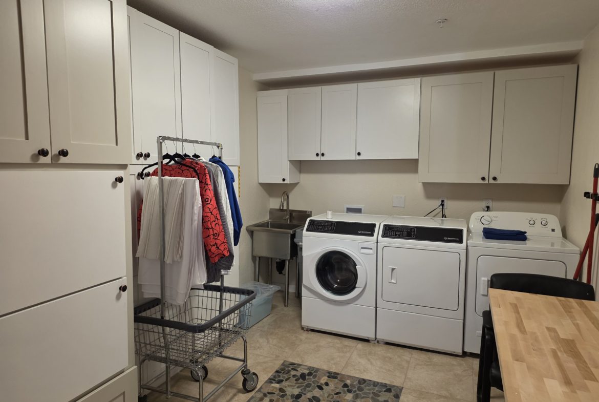 Laundry room with washer, dryer, and clothes.