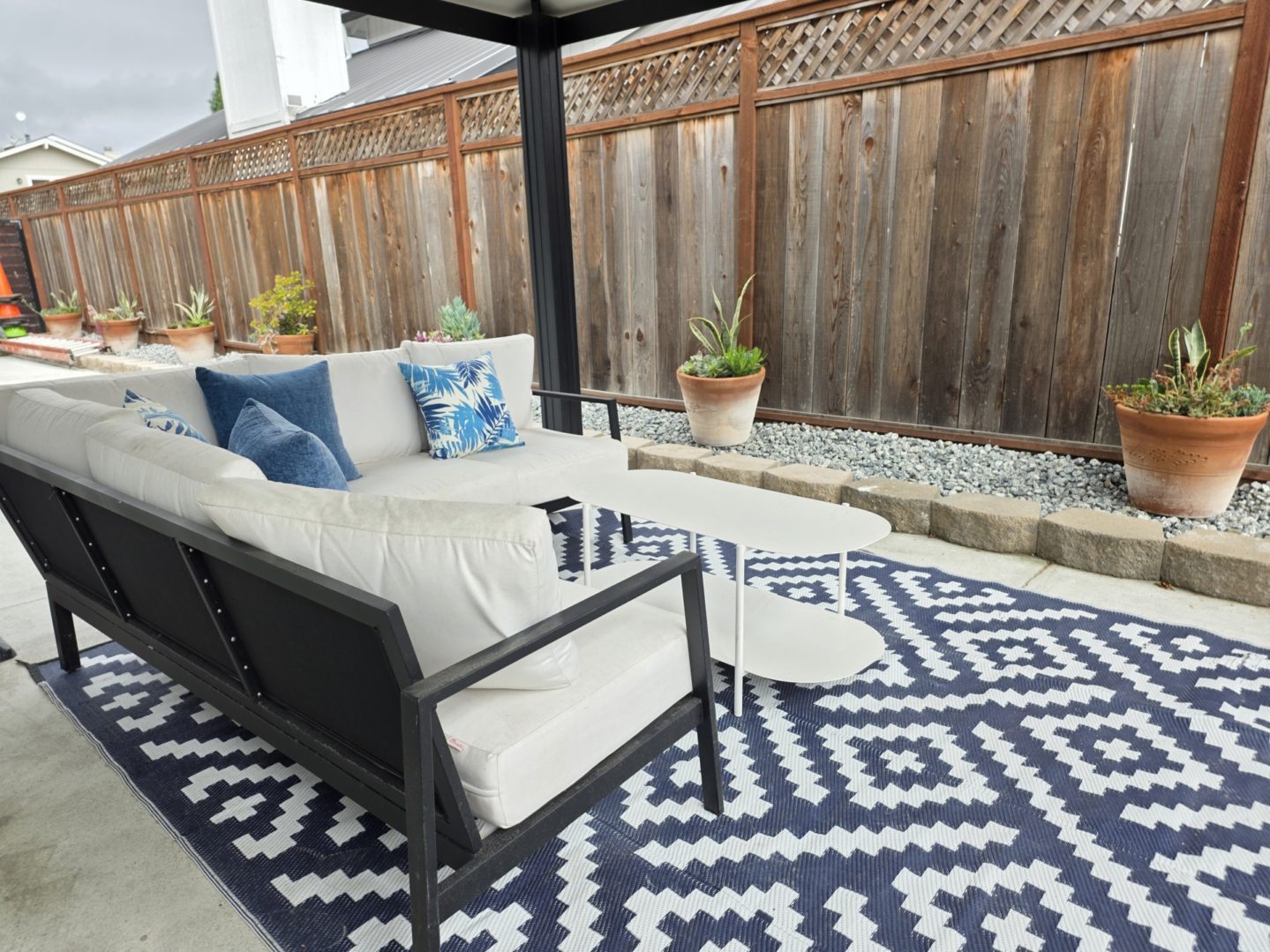 Outdoor patio with couch and decorative pillows.