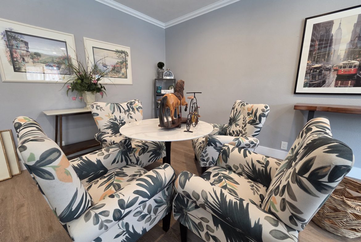Floral chairs around a small round table.