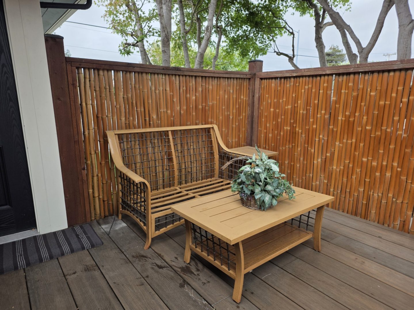 Outdoor patio with wooden furniture and plants.