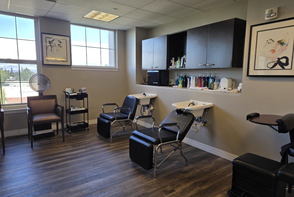 Hair salon with chairs and washing stations.