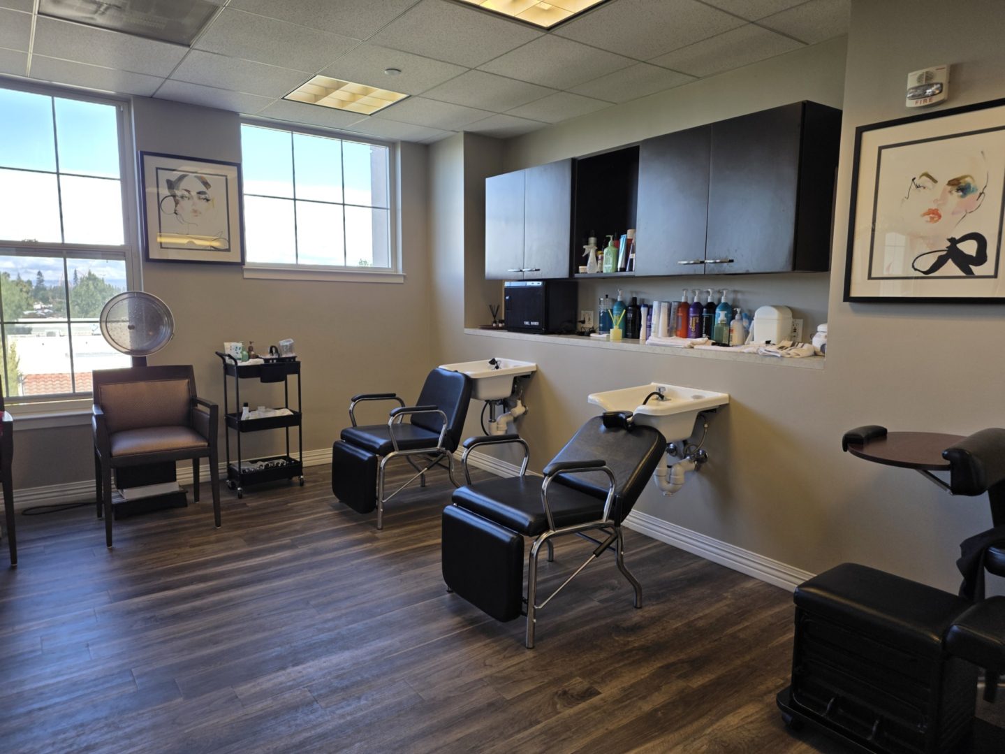 Hair salon with chairs and washing stations.