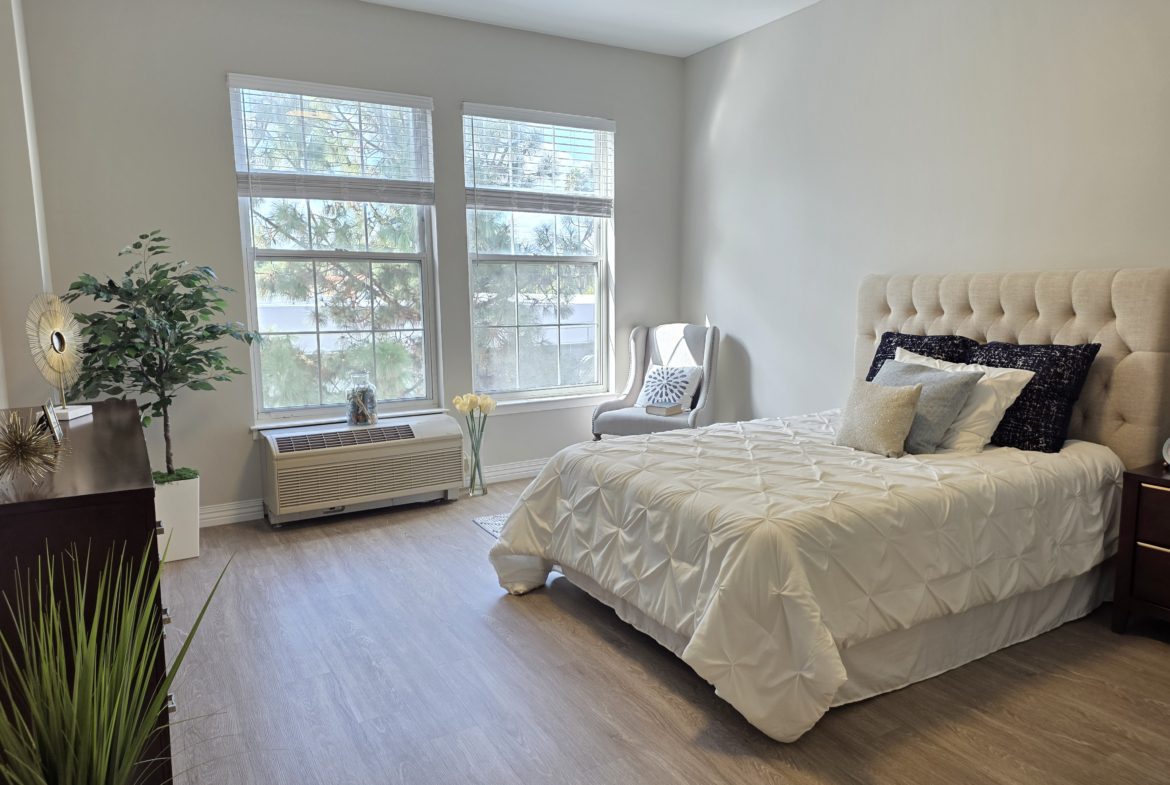 Bright bedroom with large window and bed.