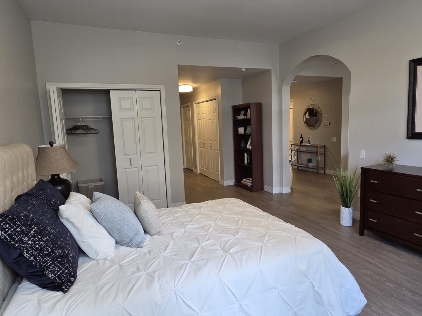 Modern bedroom with white bedding and closet.