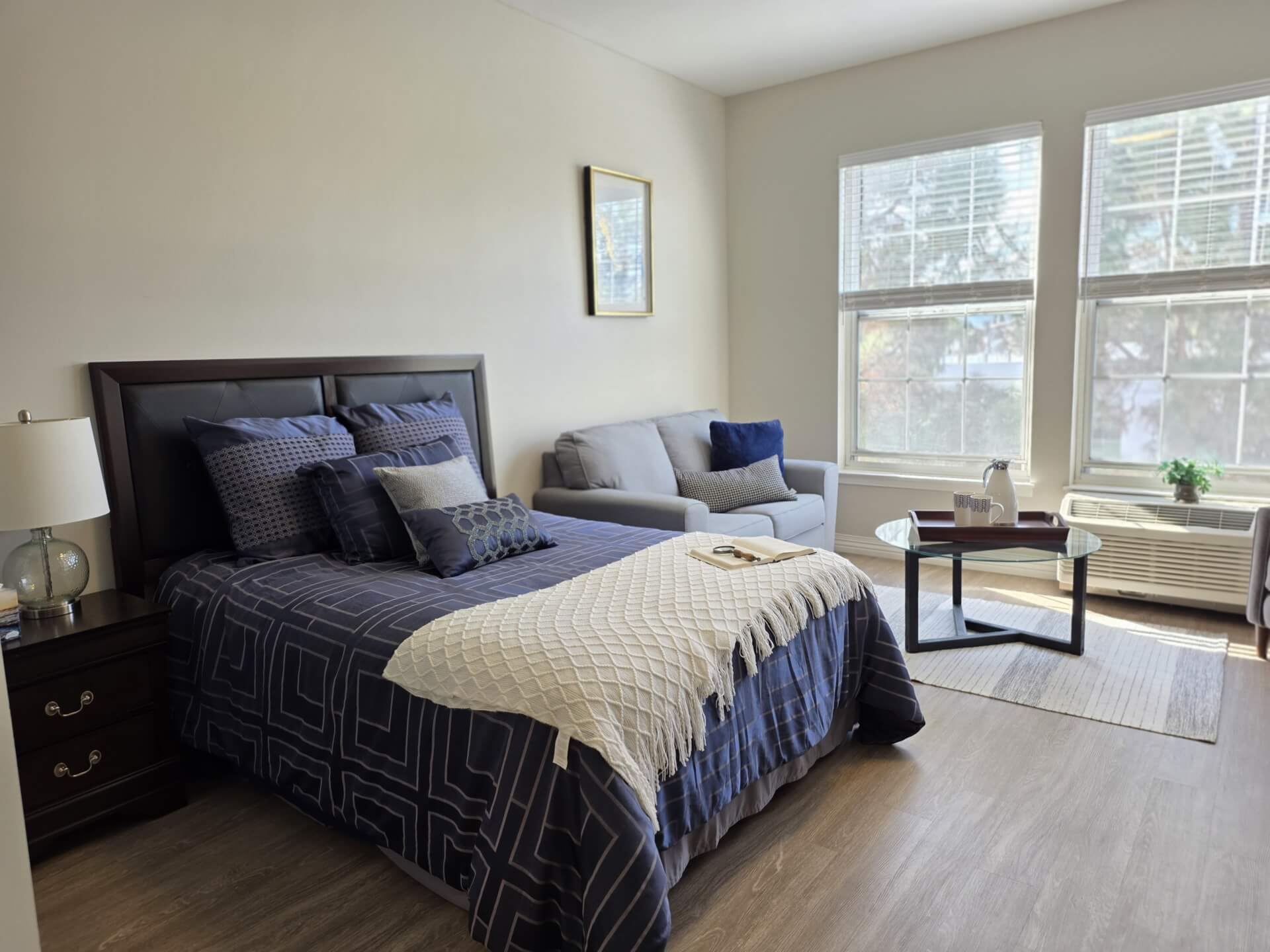 Modern bedroom with bed, sofa, and window.