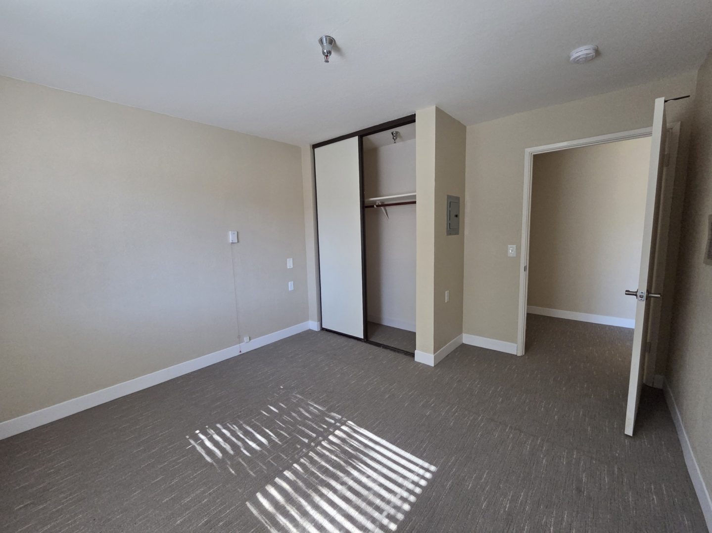Empty room with open closet and door.