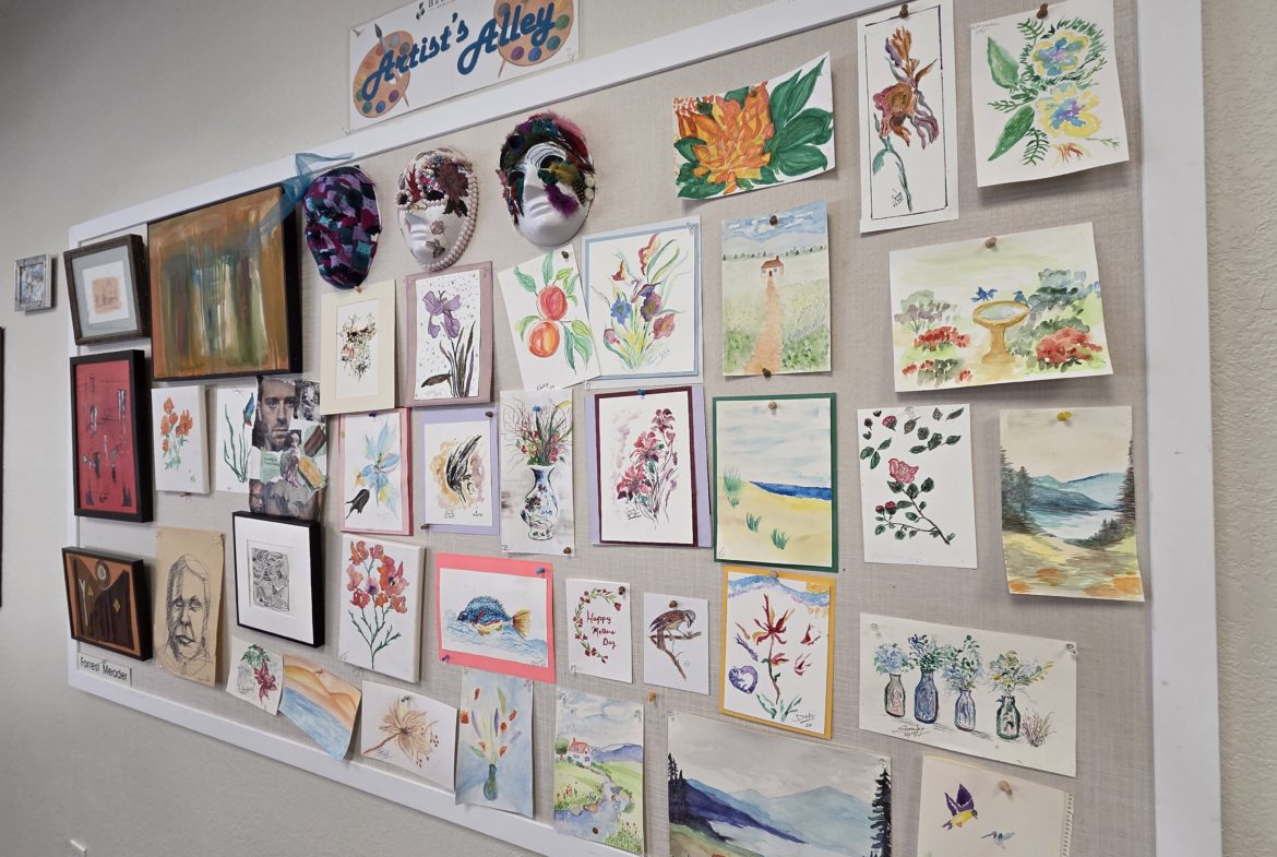 Bulletin board displaying various colorful artworks.