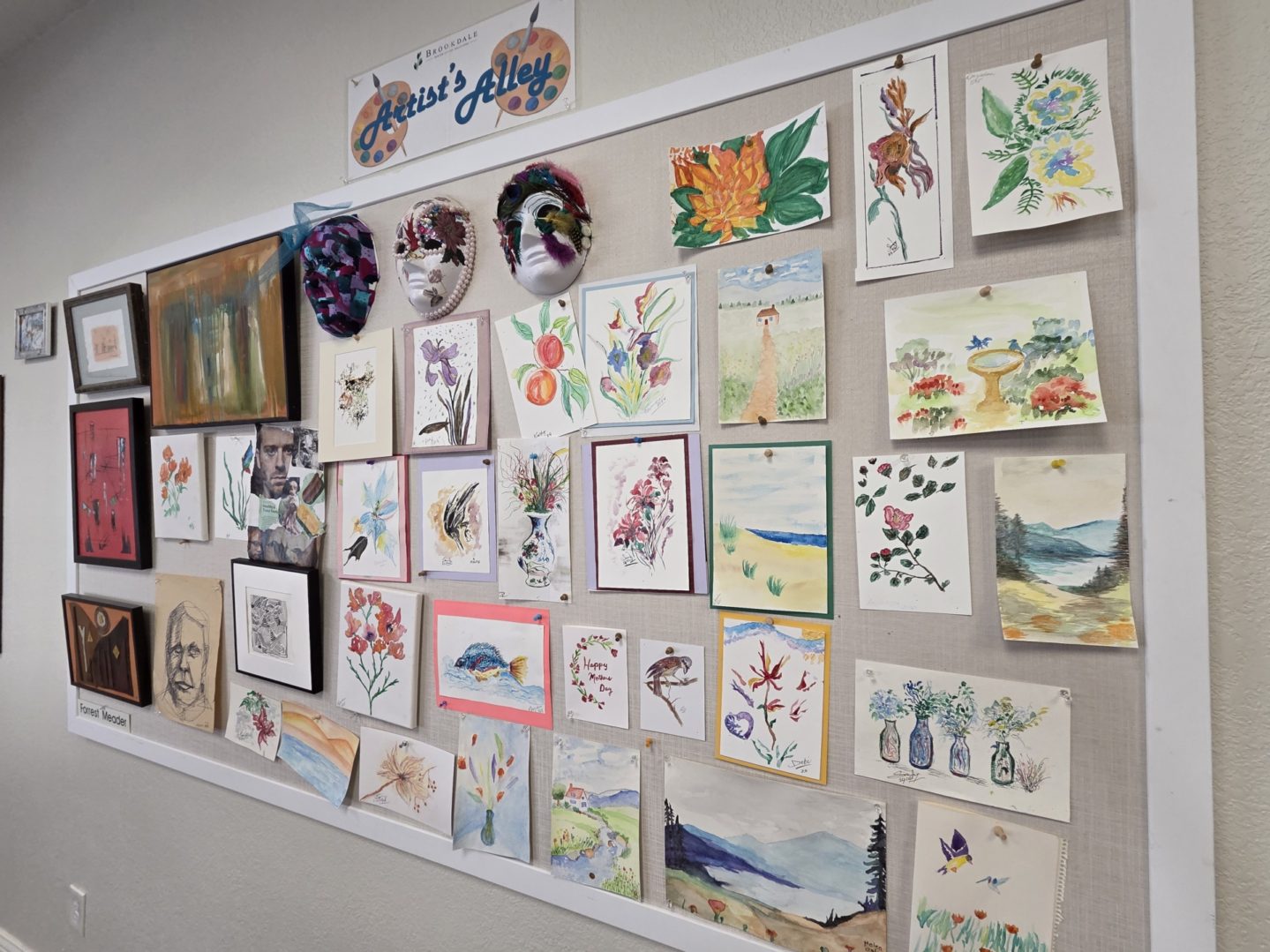 Bulletin board displaying various colorful artworks.