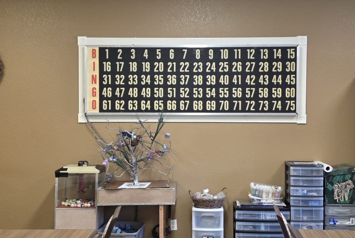 Bingo board on wall with decorations below.