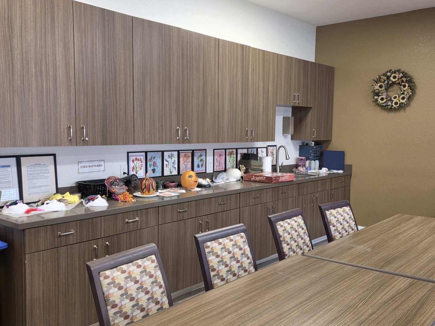 Office kitchen with cabinets and table setup.