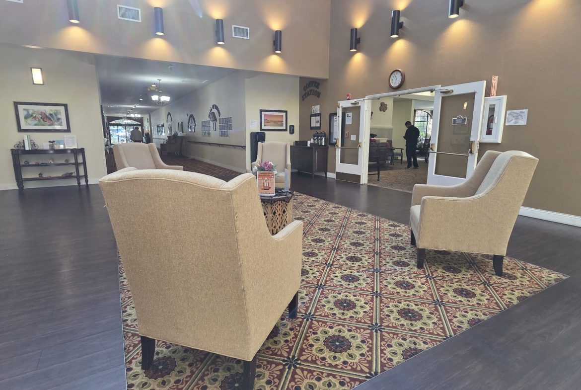 Lobby with armchairs and patterned carpet.