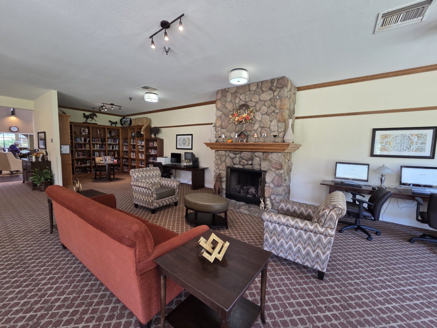 Cozy library lounge with fireplace and computers.