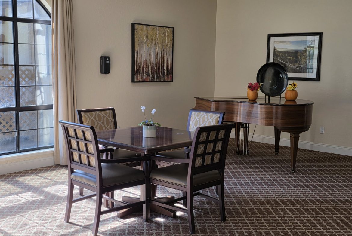Dining table and piano in elegant room.