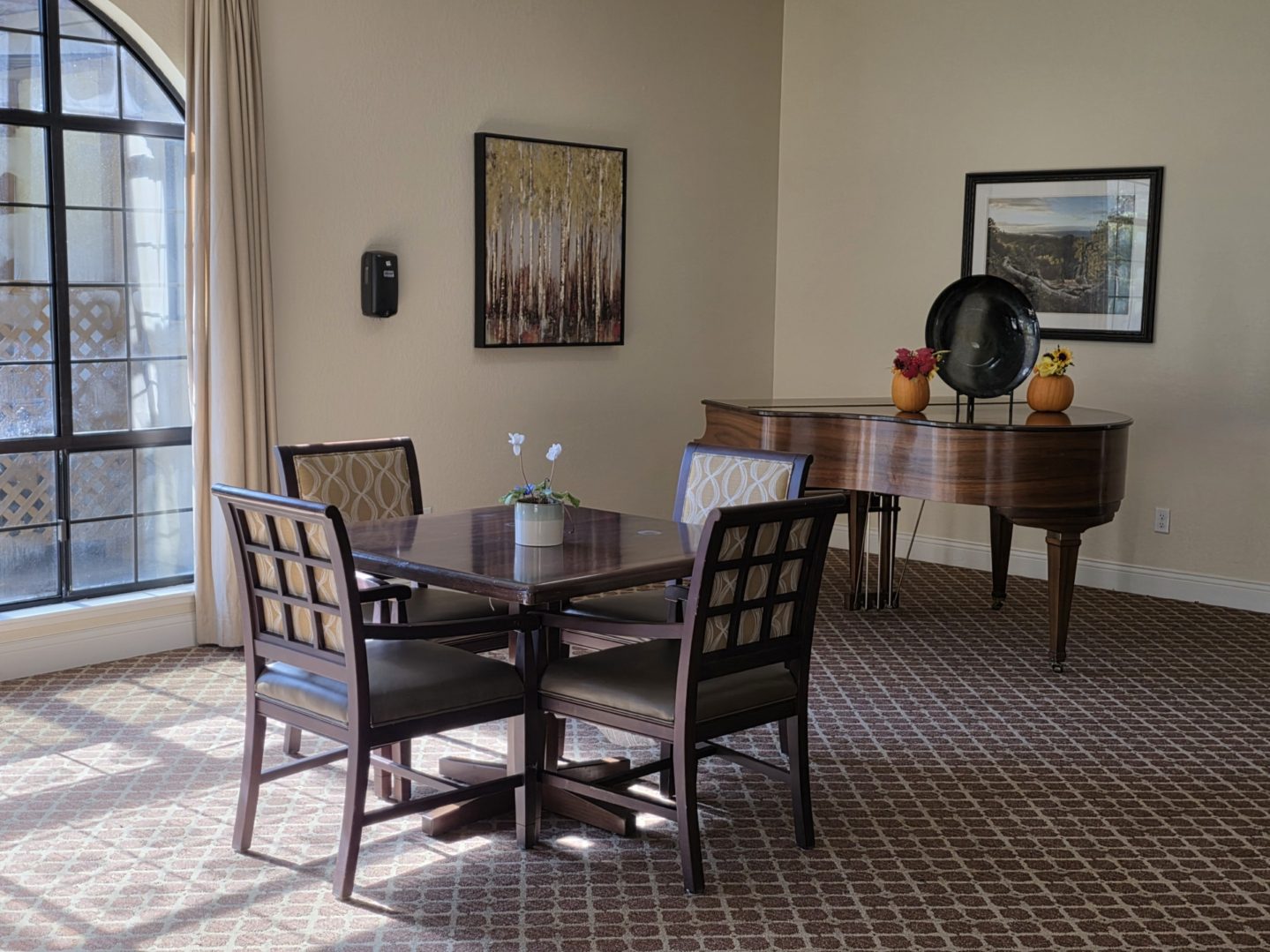 Dining table and piano in elegant room.