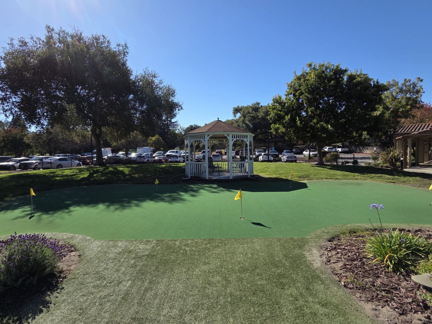 Gazebo on mini golf course under clear sky.